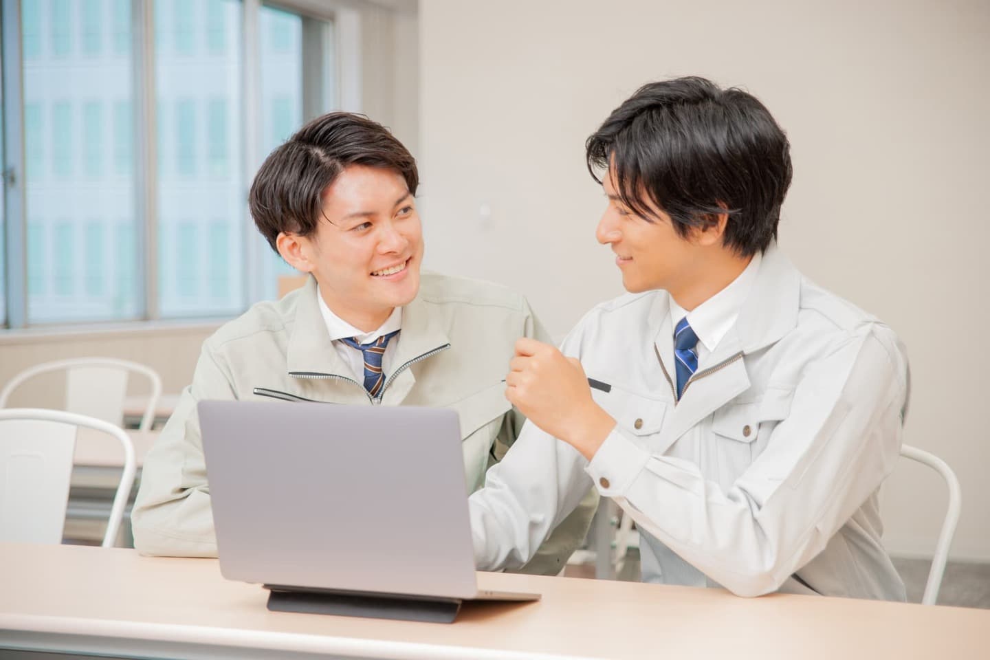 パソコンの前で笑顔をディスカッションする若い男性従業員